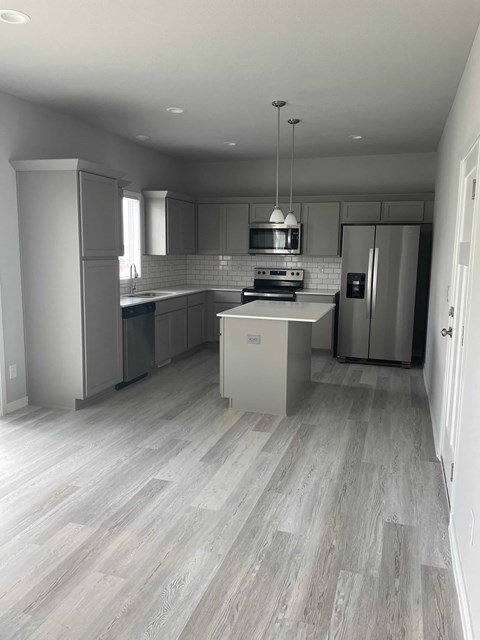 a brand new kitchen with white cabinets and stainless steel appliances