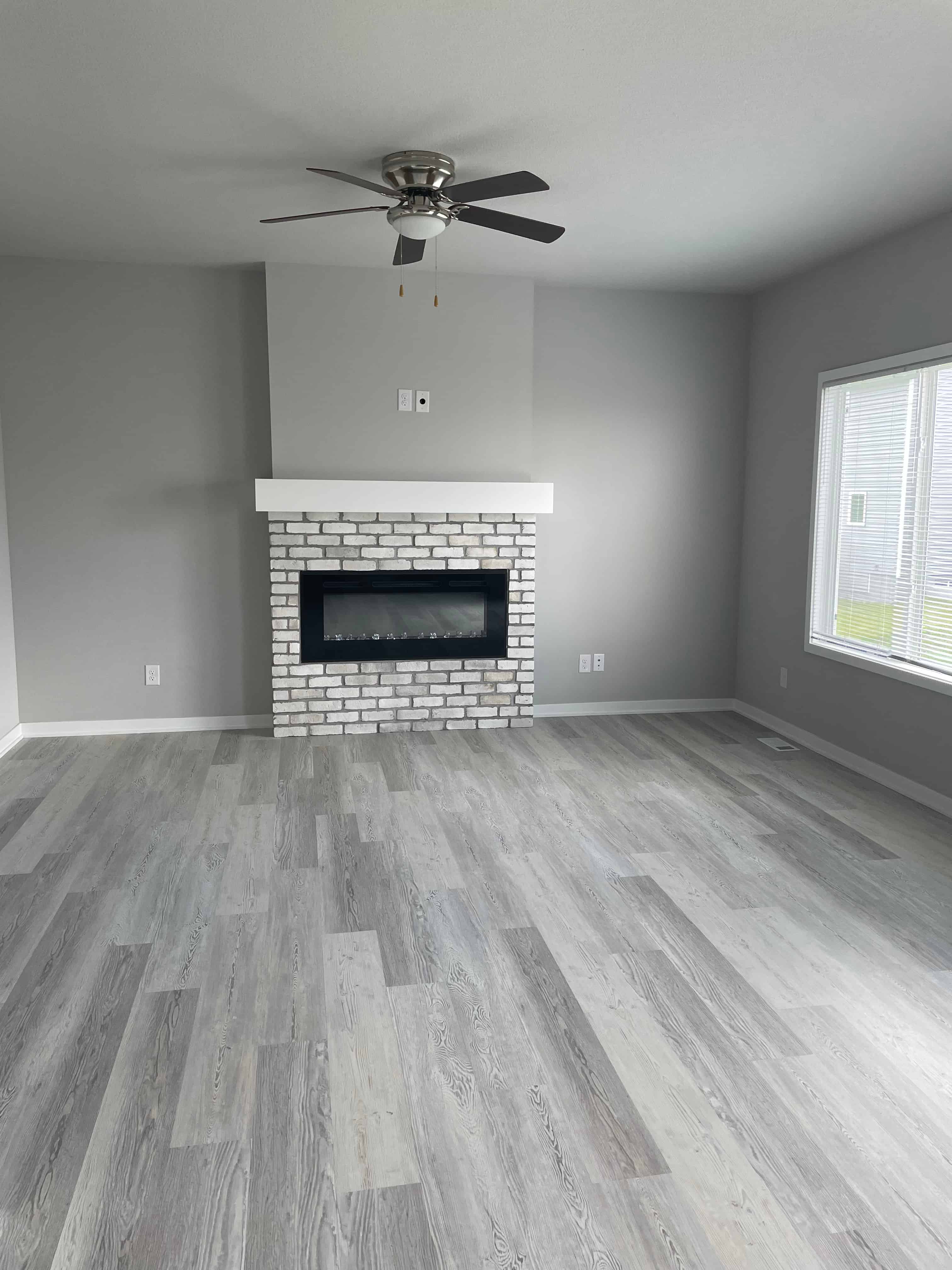 A room with a fireplace and a ceiling fan.
