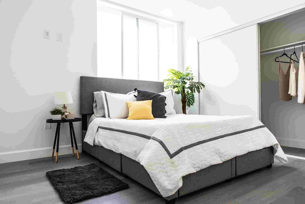 a bedroom with a large bed and a mirror