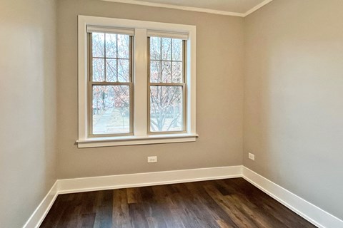 A room with a window and wooden floors.