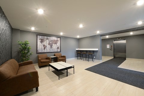A modern waiting room with a couch, chairs, and a table.