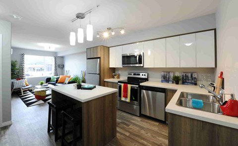 A modern kitchen with a wooden island and stainless steel appliances.