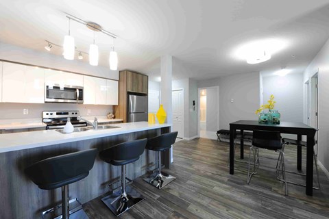 A kitchen with a bar area and a dining table.