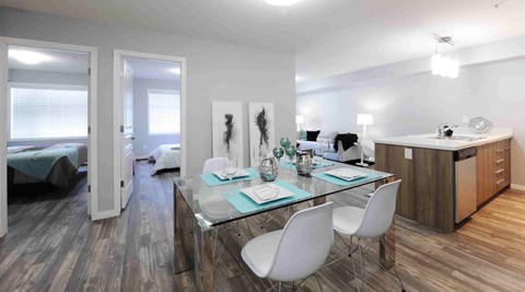 A modern kitchen with a glass table and white chairs.