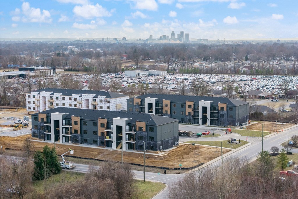 an aerial view of an apartment complex with a city in the background