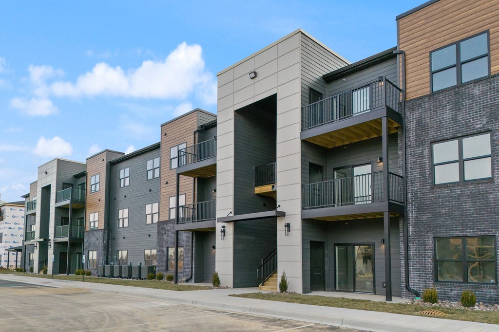 a row of new apartment buildings with balconies and a street