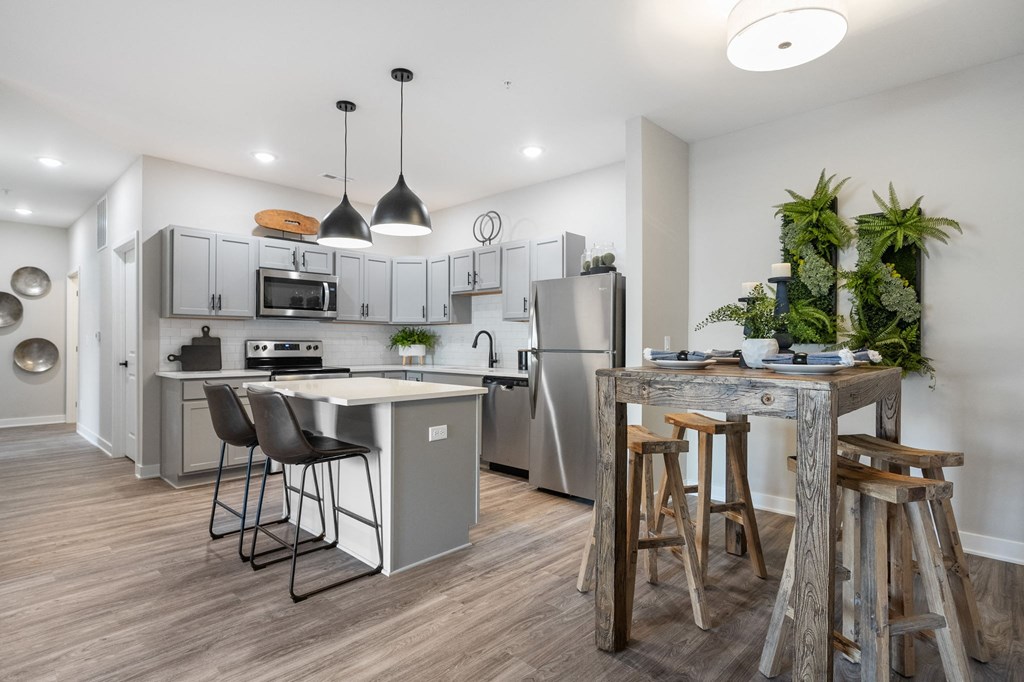 a kitchen with stainless steel appliances and a bar with stools