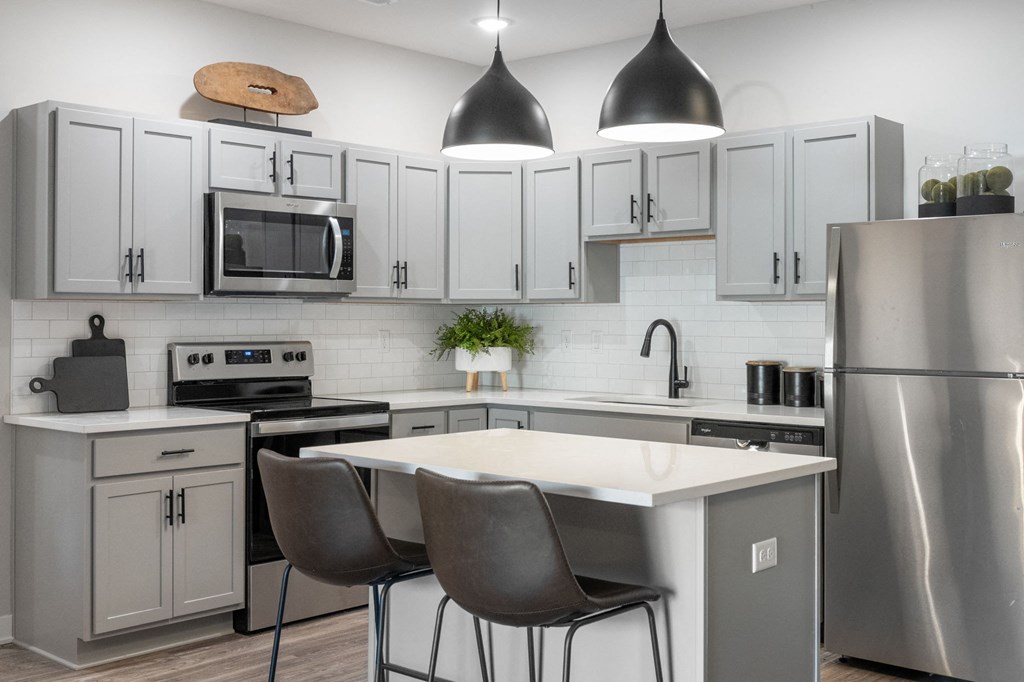 a kitchen with white cabinets and stainless steel appliances