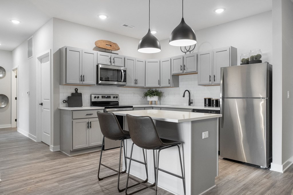 a kitchen with stainless steel appliances and white cabinetry