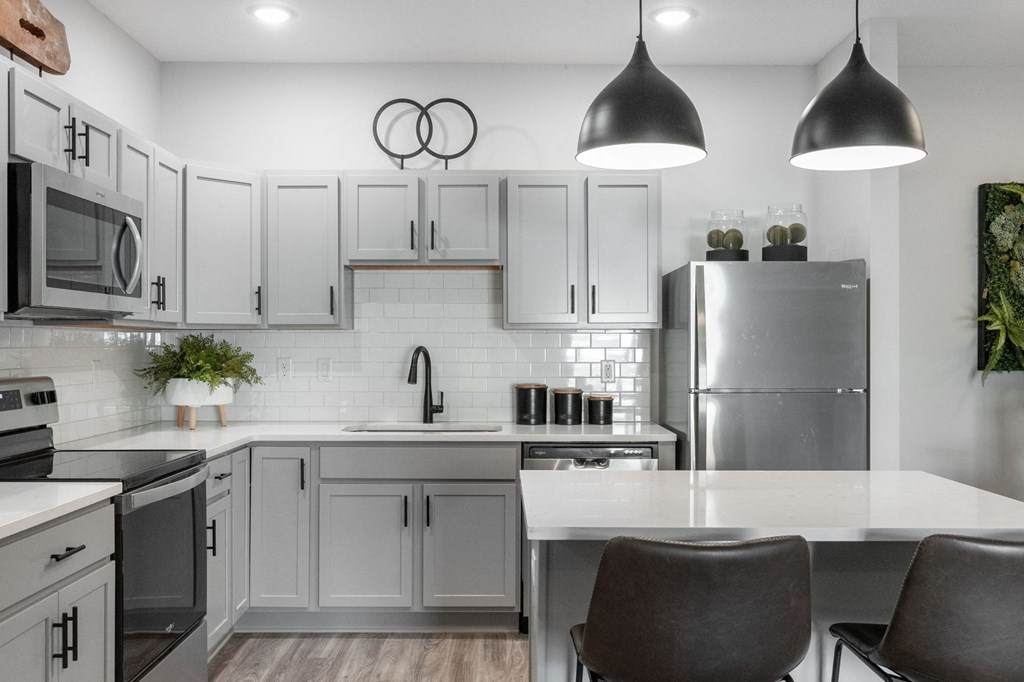 a kitchen with white cabinets and stainless steel appliances and a white counter top