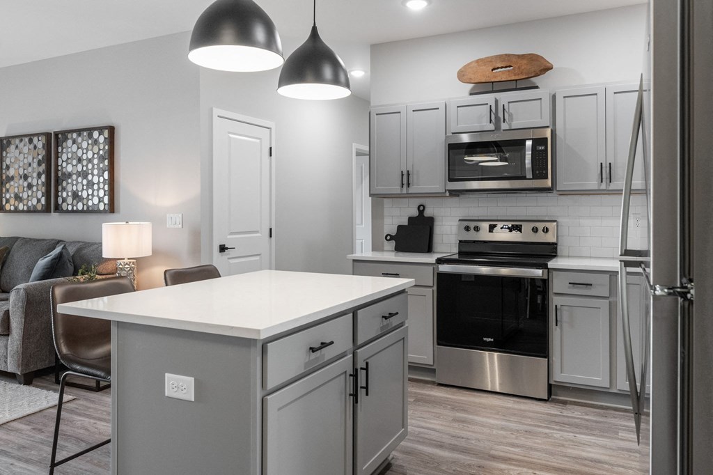 a kitchen with white cabinets and stainless steel appliances and a white counter top