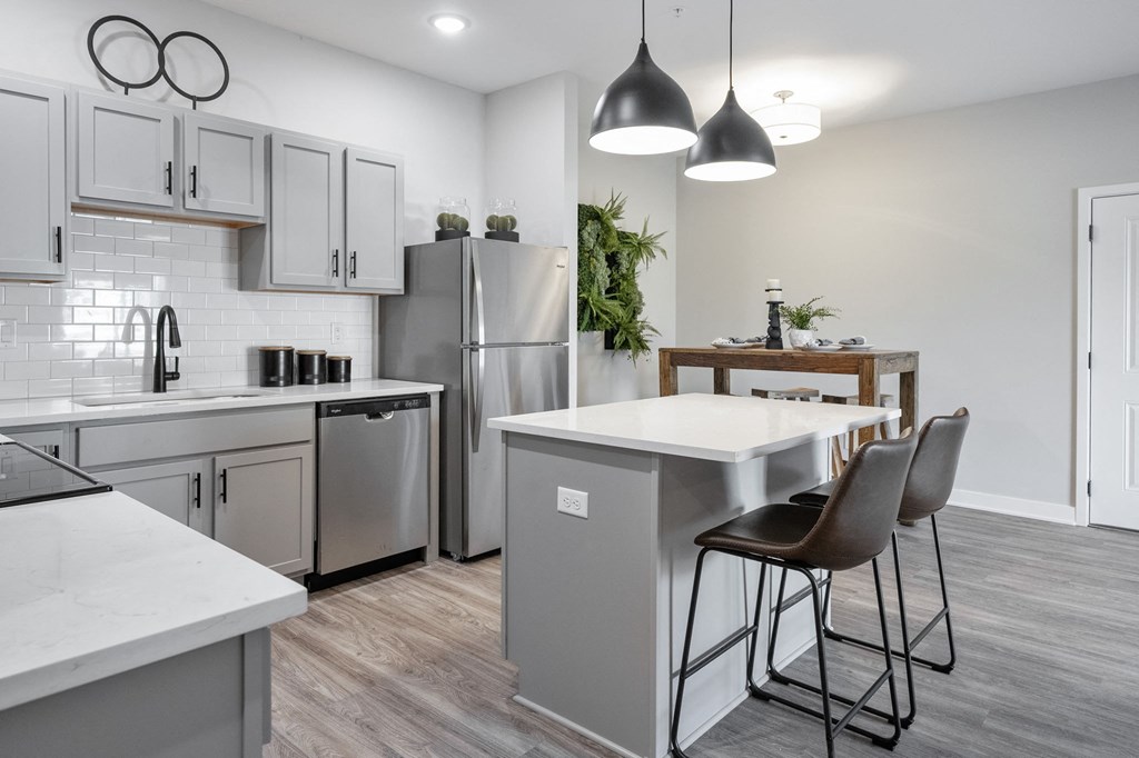 an open kitchen and dining area with a large island and stainless steel appliances