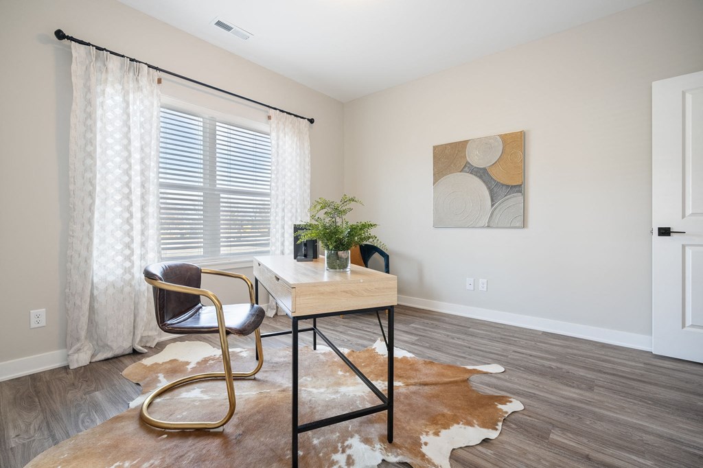 a home office with a desk and chair and a window