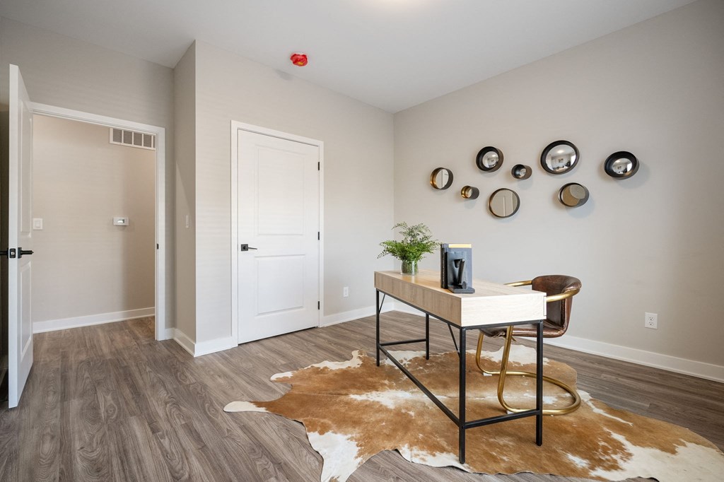 an office with a desk and a rug and a door