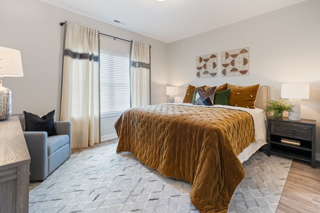 a bedroom with a bed and a chair and a window