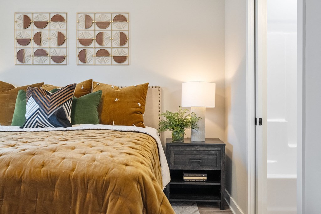 a bedroom with a bed and pillows and a night stand