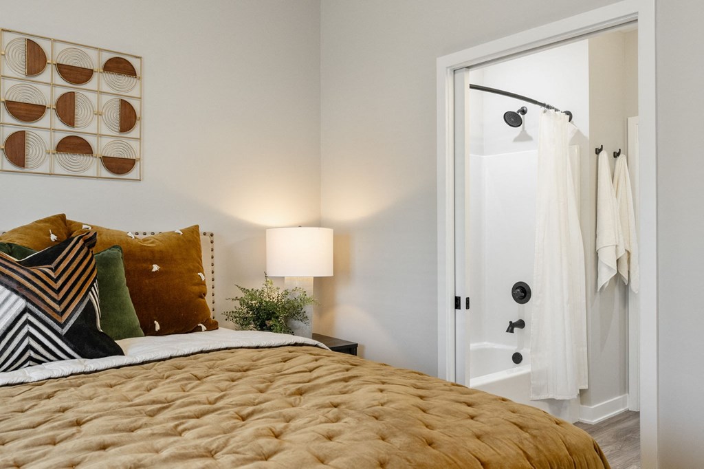 a bedroom with a bed and an open door to the bathroom