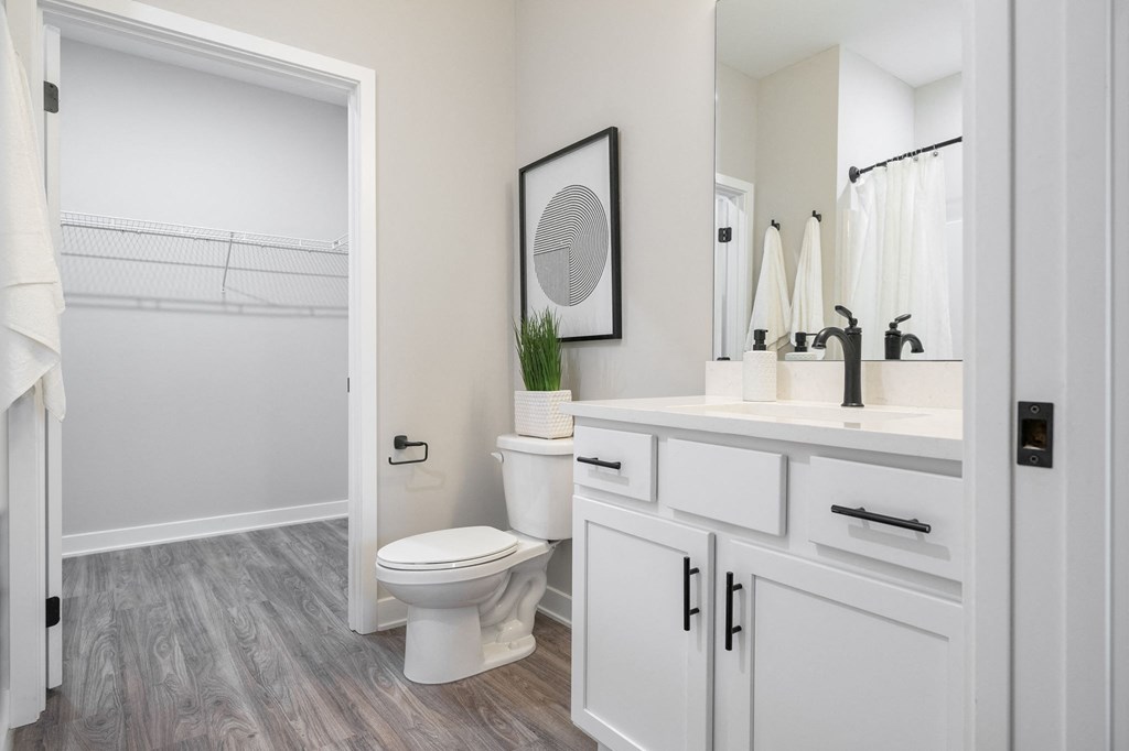 an open bathroom with white cabinets and a toilet and a sink