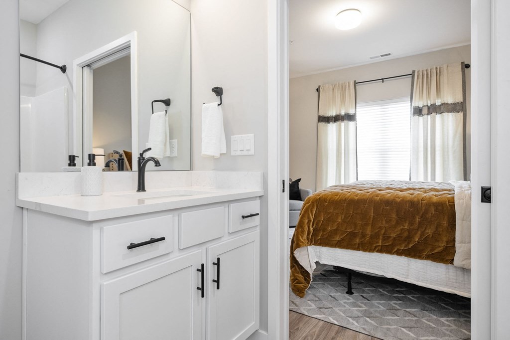 a bedroom with a bed and a sink and a mirror