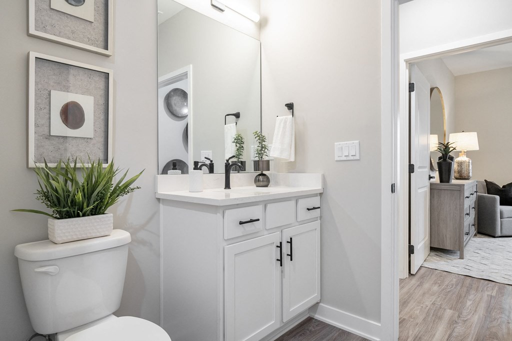 a white bathroom with a white toilet and a sink