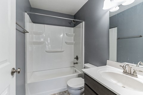 a bathroom with a shower and a sink and a toilet