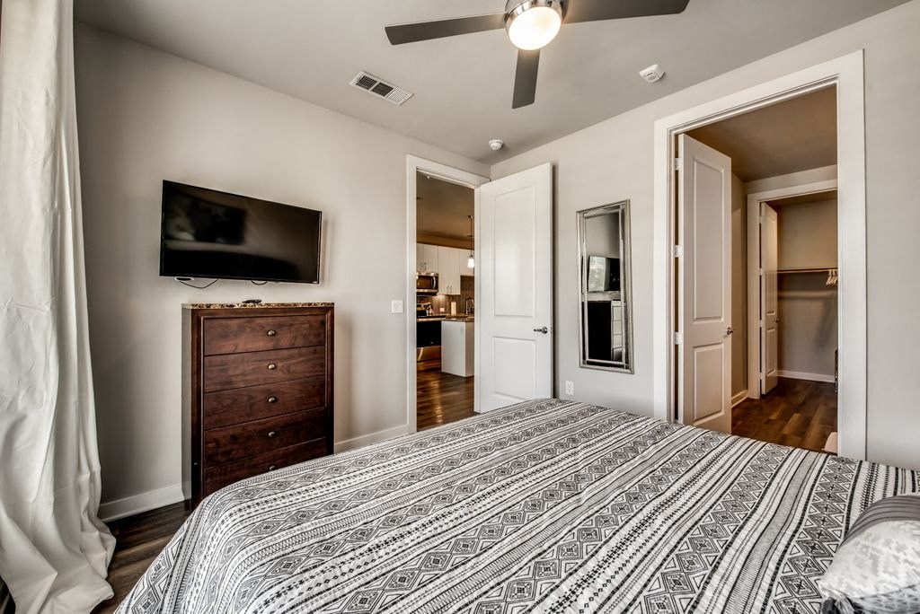 a bedroom with a bed and a ceiling fan