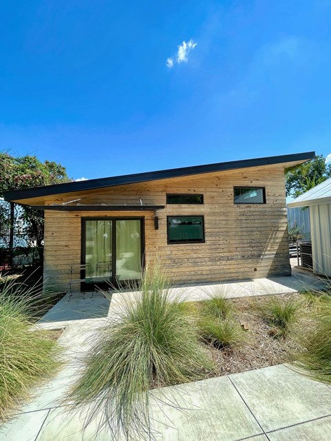 A modern house with a wooden exterior and glass windows.