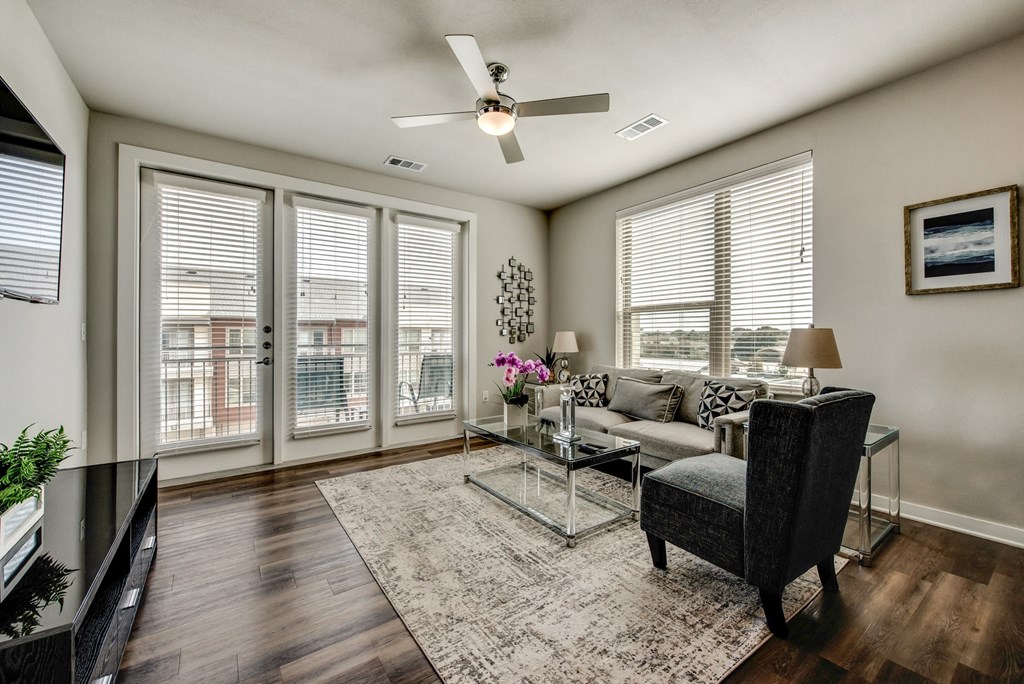 a living room with a couch and a chair and a ceiling fan