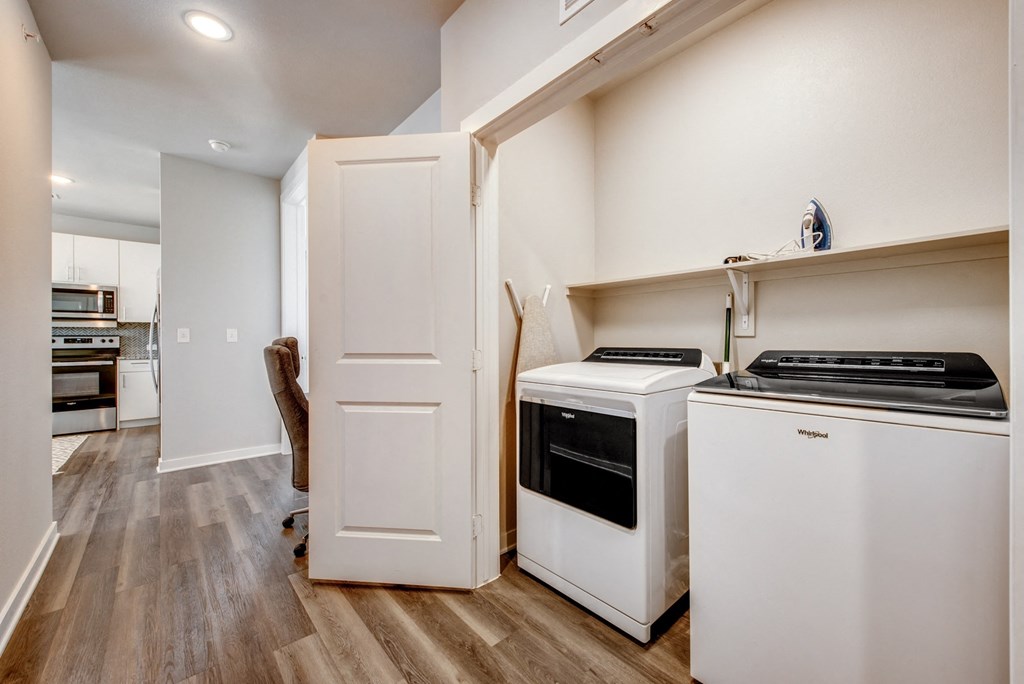 a kitchen with white appliances and white cabinets and a white door