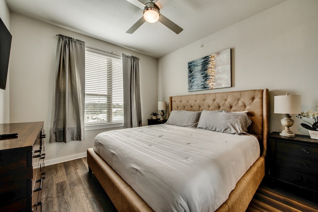 a bedroom with a large bed and a ceiling fan