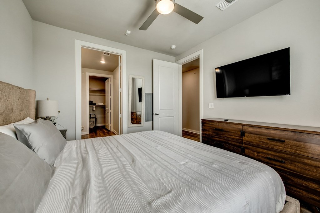 the master bedroom has a large bed and a tv