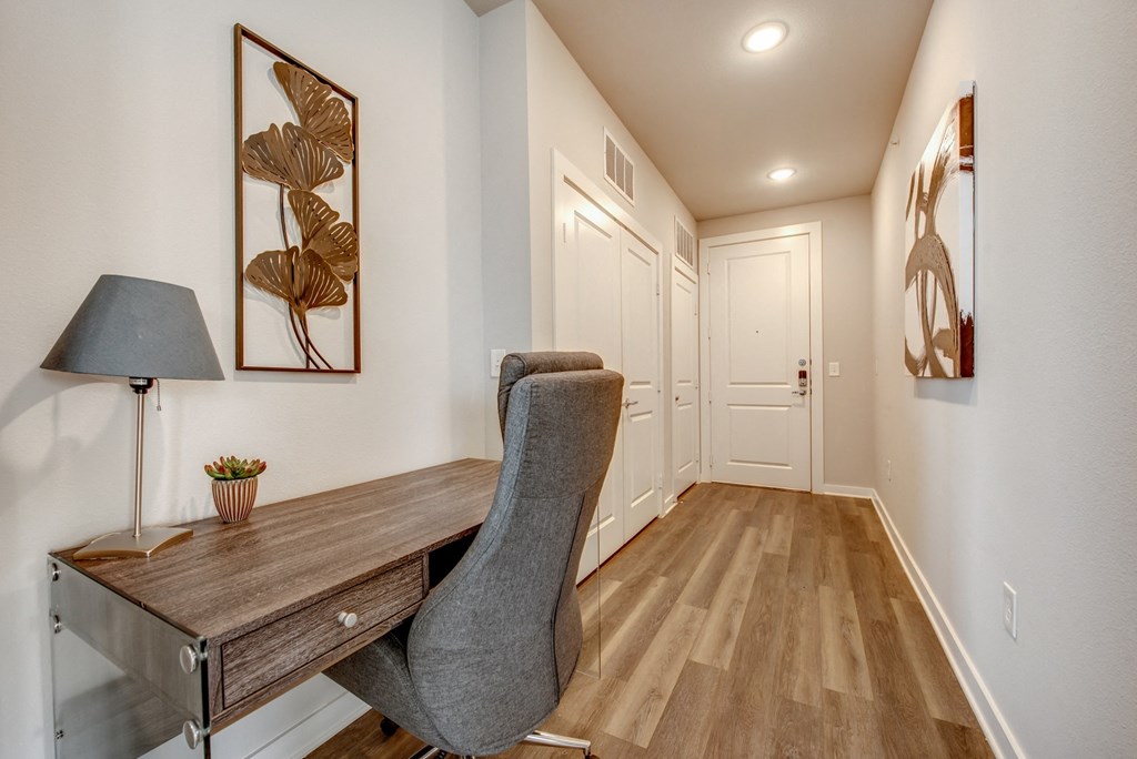 an office with a desk and a chair in a room with a hallway and doors