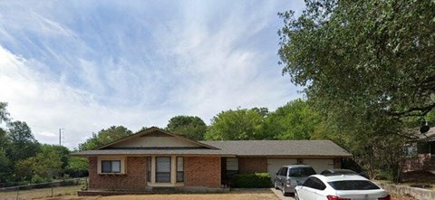 A house with a car parked in front.