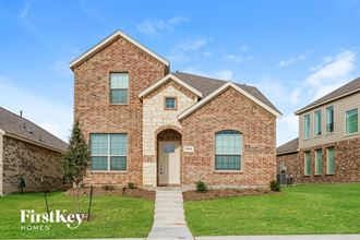 side view of a brick home with green grass and a blue sky