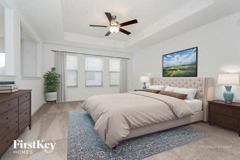 A bedroom with a large bed and a ceiling fan.