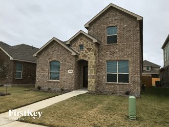 a brick house with a sidewalk in front of it