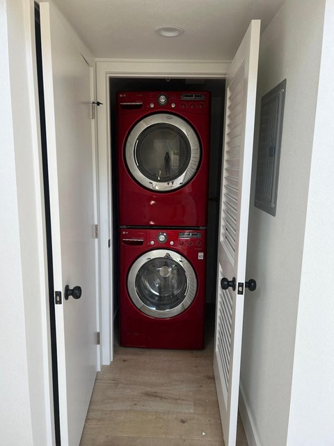 a red washer and dryer in a narrow hallway