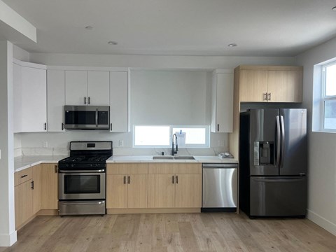 a kitchen with white cabinets and stainless steel appliances