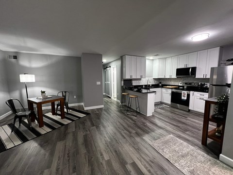 A kitchen with a dining table and chairs.