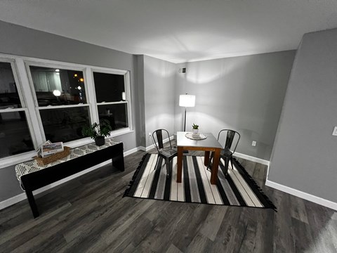 A living room with a black and white striped rug, a wooden coffee table, and a lamp.