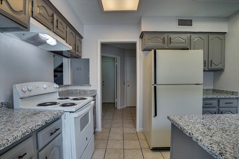 a kitchen with white appliances and granite counter tops