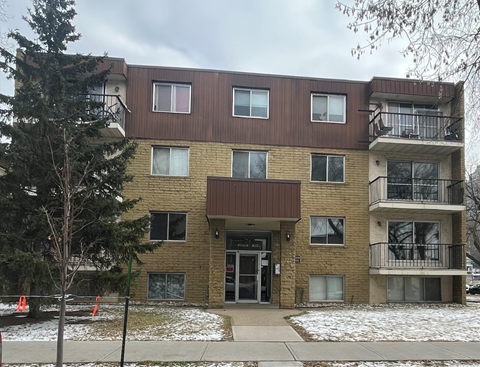 a brick apartment building with snow on the ground