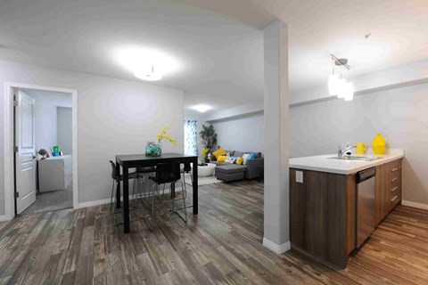 A kitchen area with a table and chairs in the middle of the room.