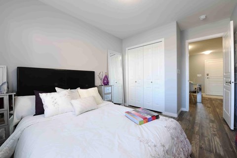 A bedroom with a large bed and a white headboard.