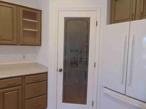 a kitchen with a refrigerator and a door with graffiti on it