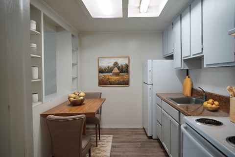 A kitchen with a table and chairs and a painting on the wall.