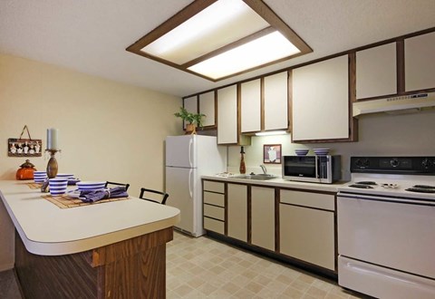 A kitchen with a white counter and a white refrigerator.