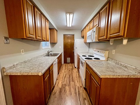 a kitchen with wood flooring and granite counter tops