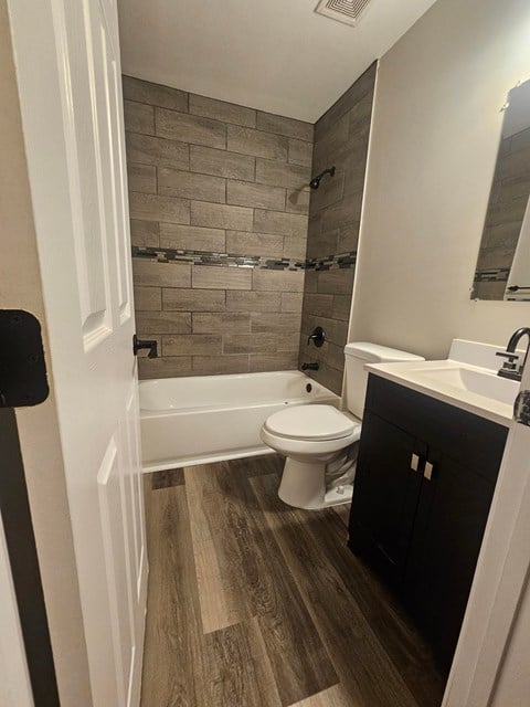A bathroom with a toilet, sink, and a bathtub.
