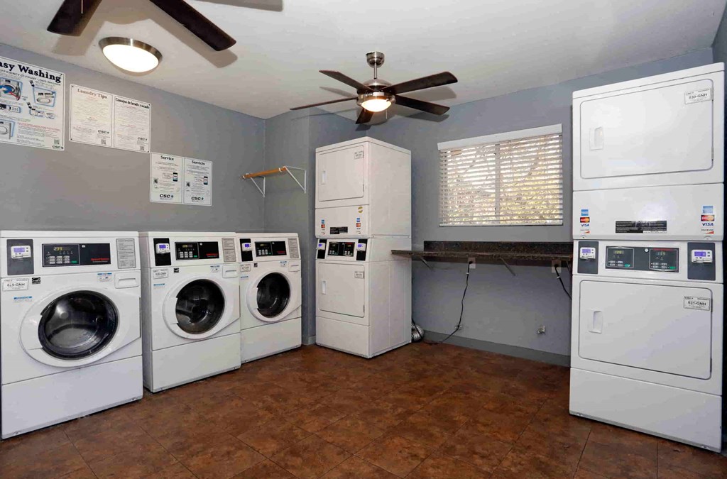 a laundry room with washer and dryers and a ceiling fan